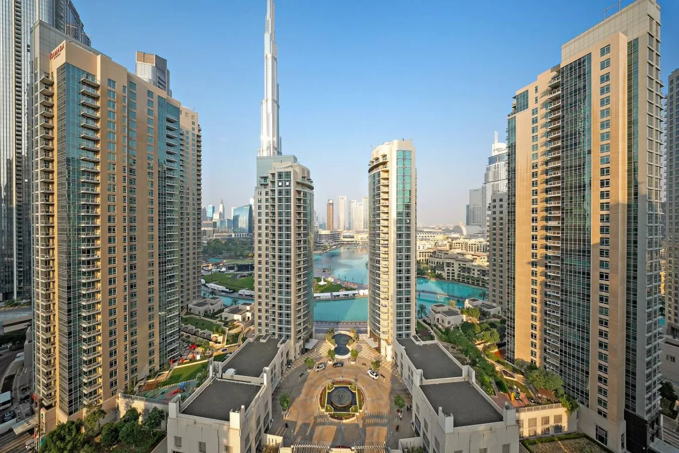 Vista urbana de altas torres residenciales alrededor de una piscina turquesa.