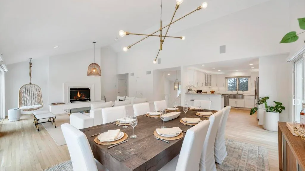 An open-plan dining and living area with a table set beside the kitchen.