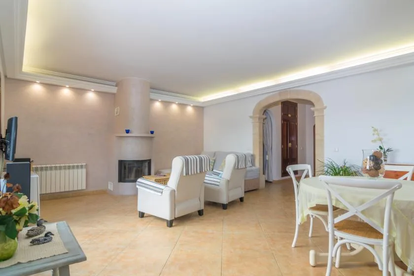 A living and dining area with seating, a fireplace, and a dining table.