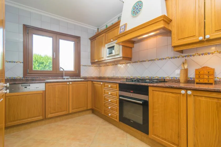 A fitted kitchen with wooden cabinets, a countertop, and a built-in oven.
