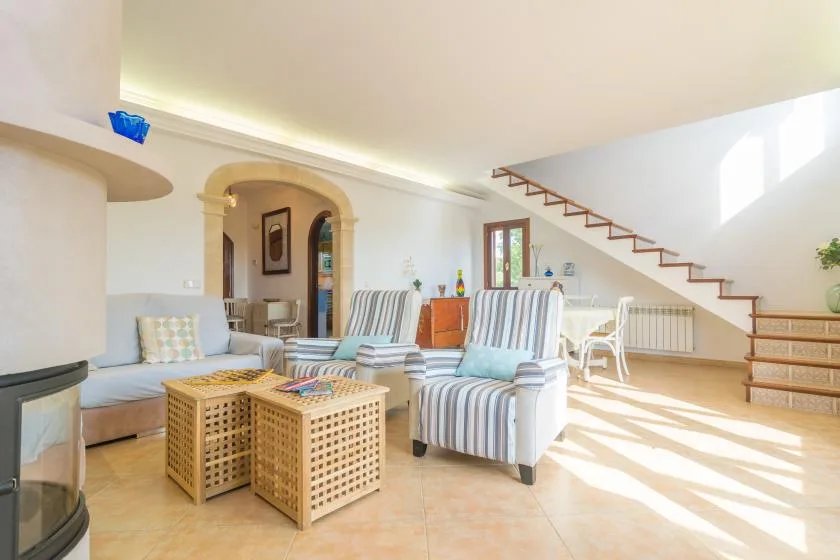 A bright living room with striped seating and wicker coffee tables.