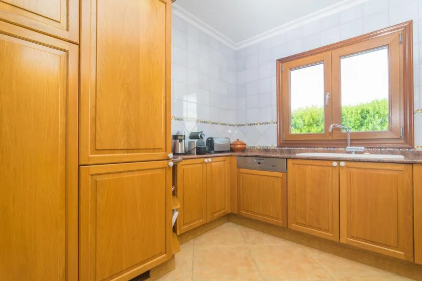 A bright kitchen with wooden cabinets and a window above the counter.