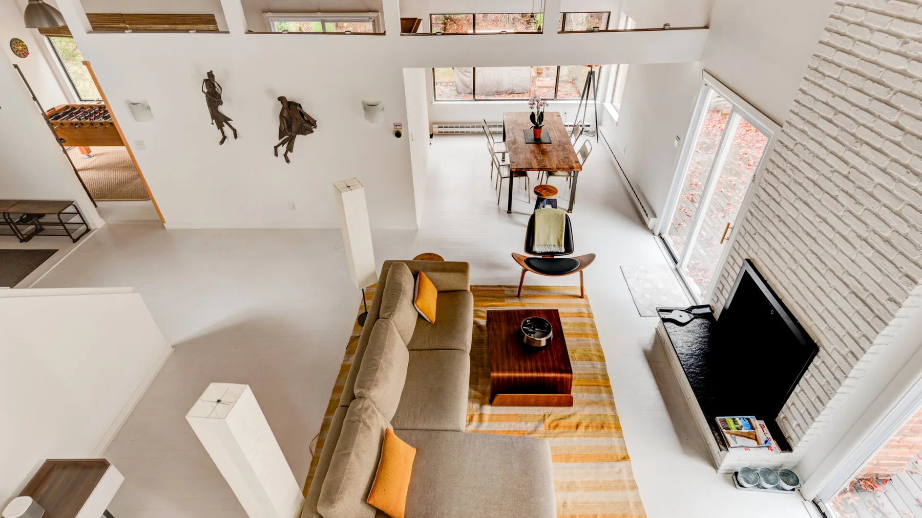 Una sala luminosa con asientos, una mesa baja y un televisor en la pared.