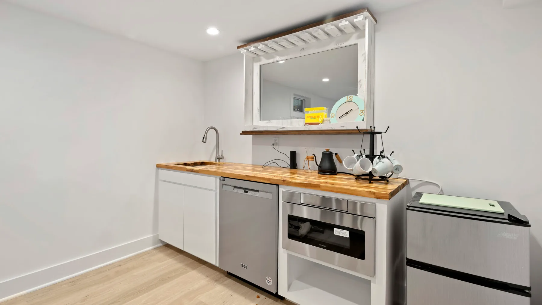 Una cocina compacta con encimera de madera, fregadero y electrodomésticos integrados.