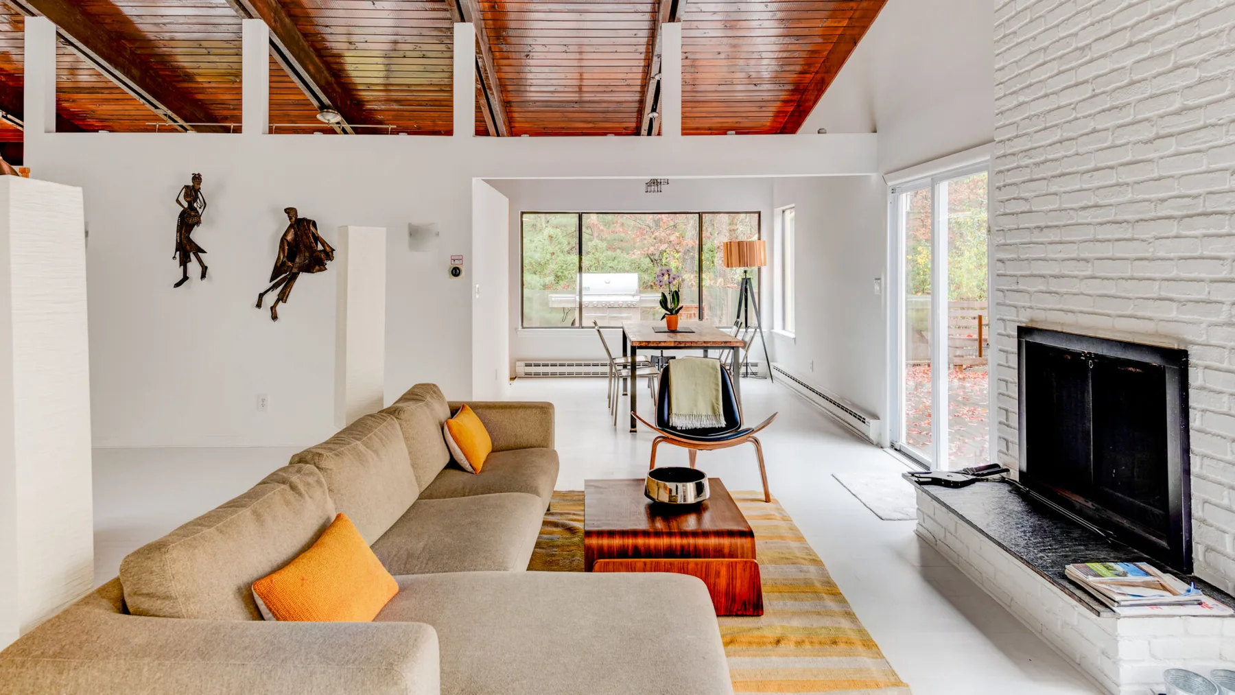 Una sala luminosa con asientos, una chimenea y un comedor.