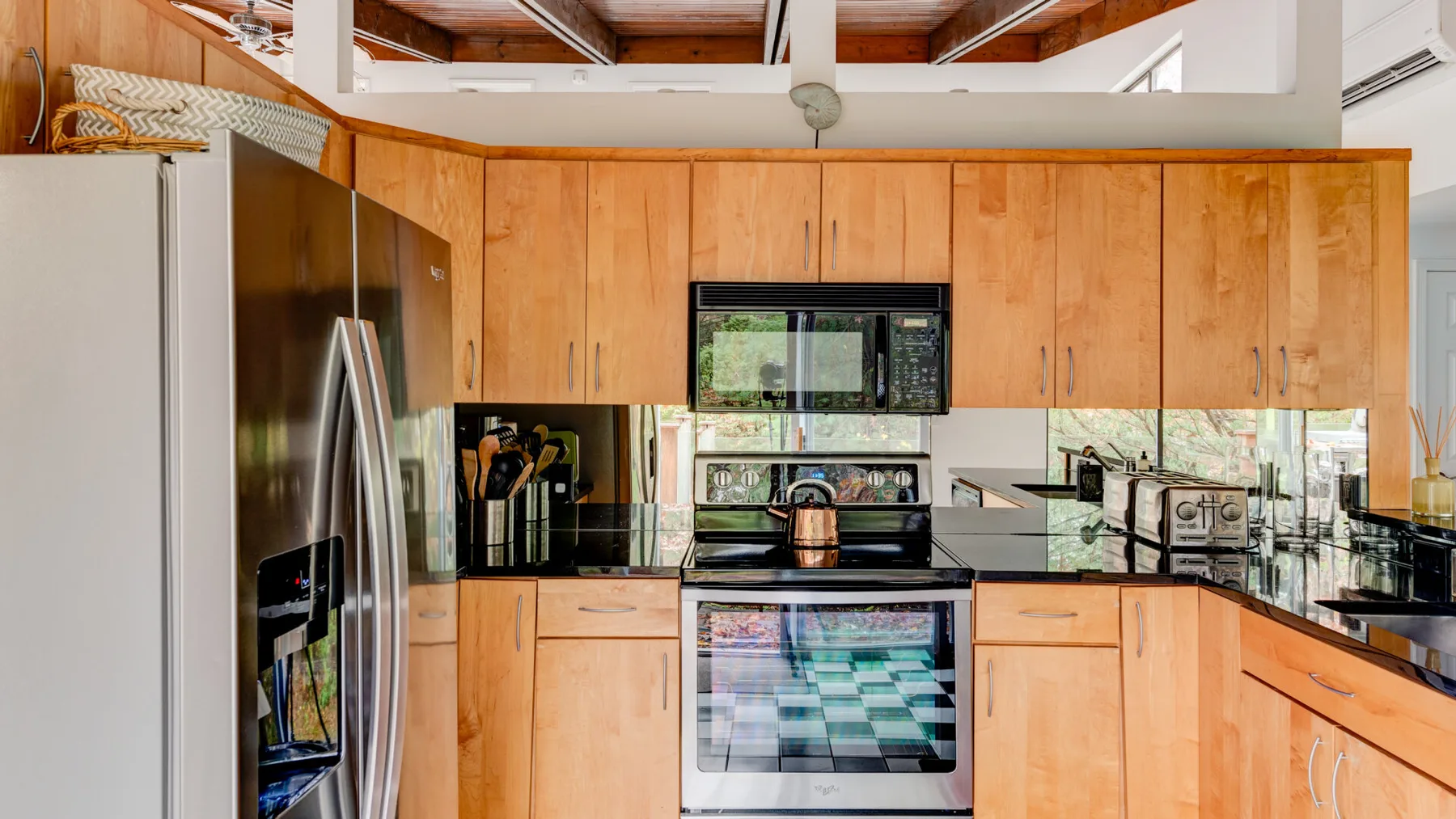 Una cocina con gabinetes de madera y electrodomésticos de acero inoxidable.