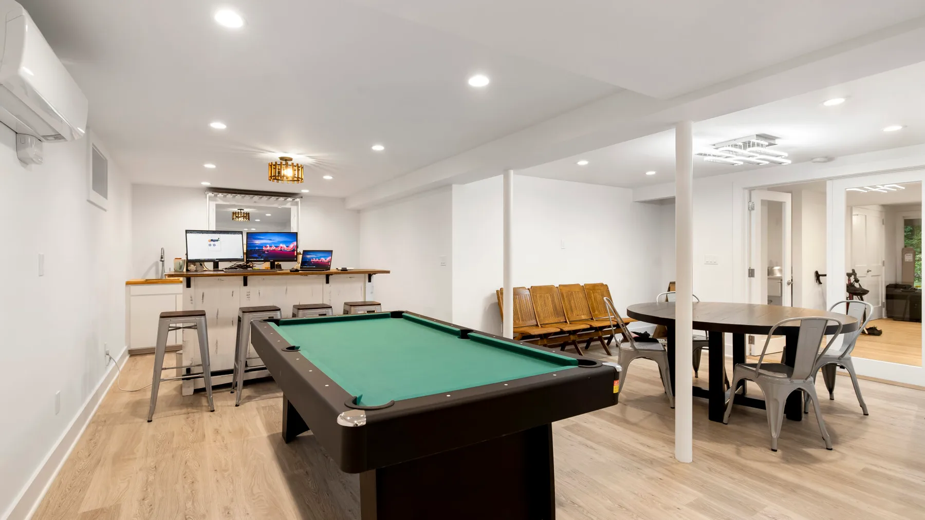 Una sala de recreación en el sótano con una mesa de billar y un comedor.