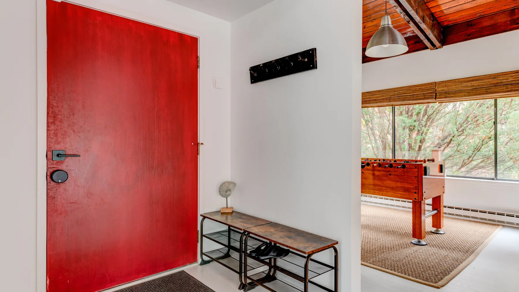 Una entrada luminosa se abre a una habitación con una mesa de futbolín.