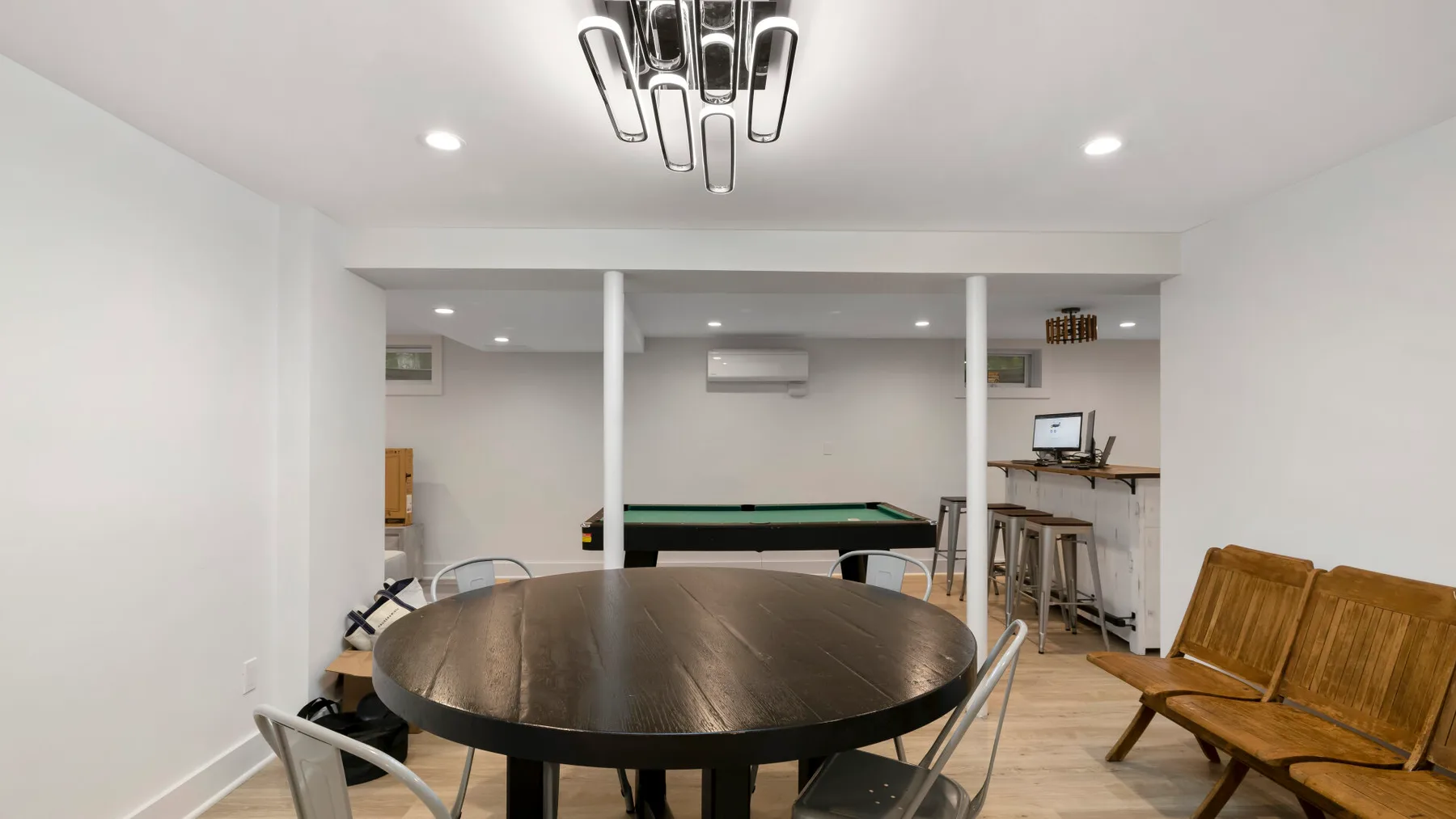Un comedor con una mesa redonda, sillas y una mesa de billar al fondo.