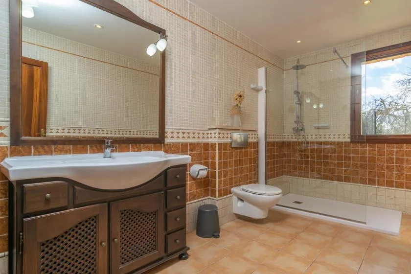 Un baño con azulejos, lavabo, inodoro y ducha de vidrio.