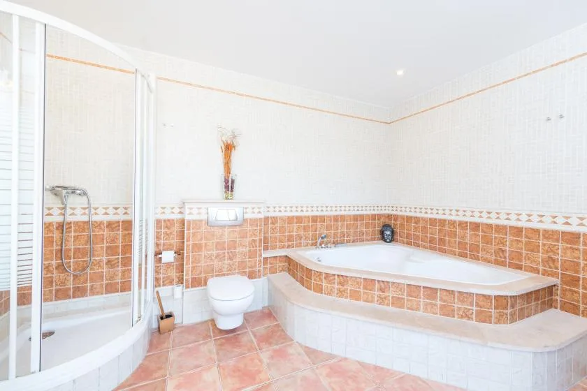 Un baño con azulejos, bañera, ducha e inodoro.