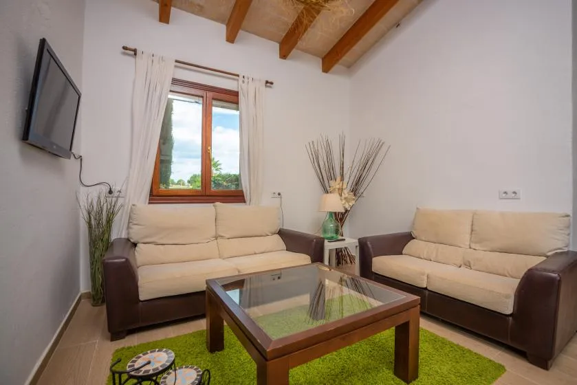 Una sala de estar con dos sofás alrededor de una mesa de centro de vidrio.