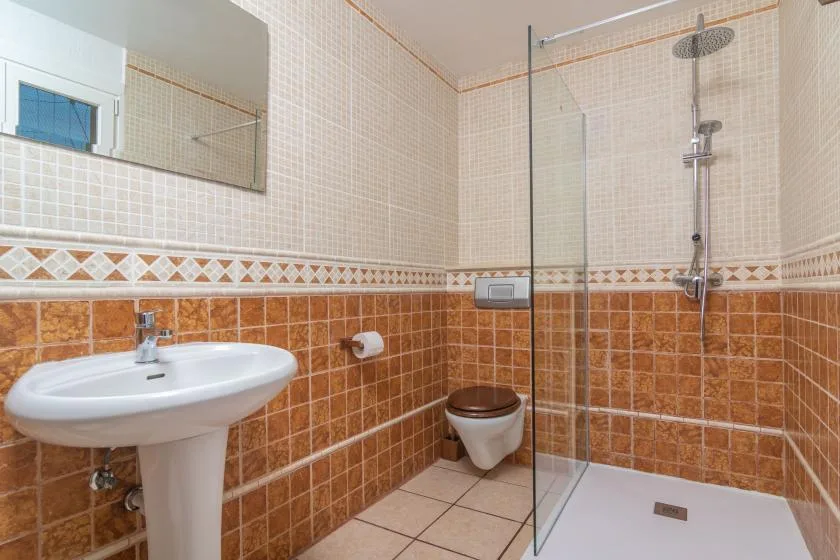 Un baño alicatado con un lavabo y una ducha de cristal.
