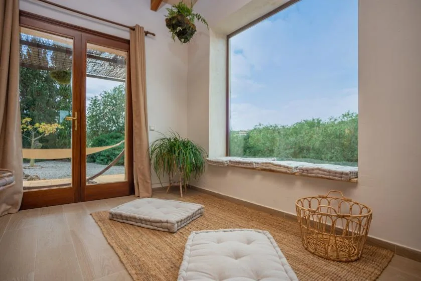 Una luminosa zona de estar con una ventana grande que da a la vegetación.