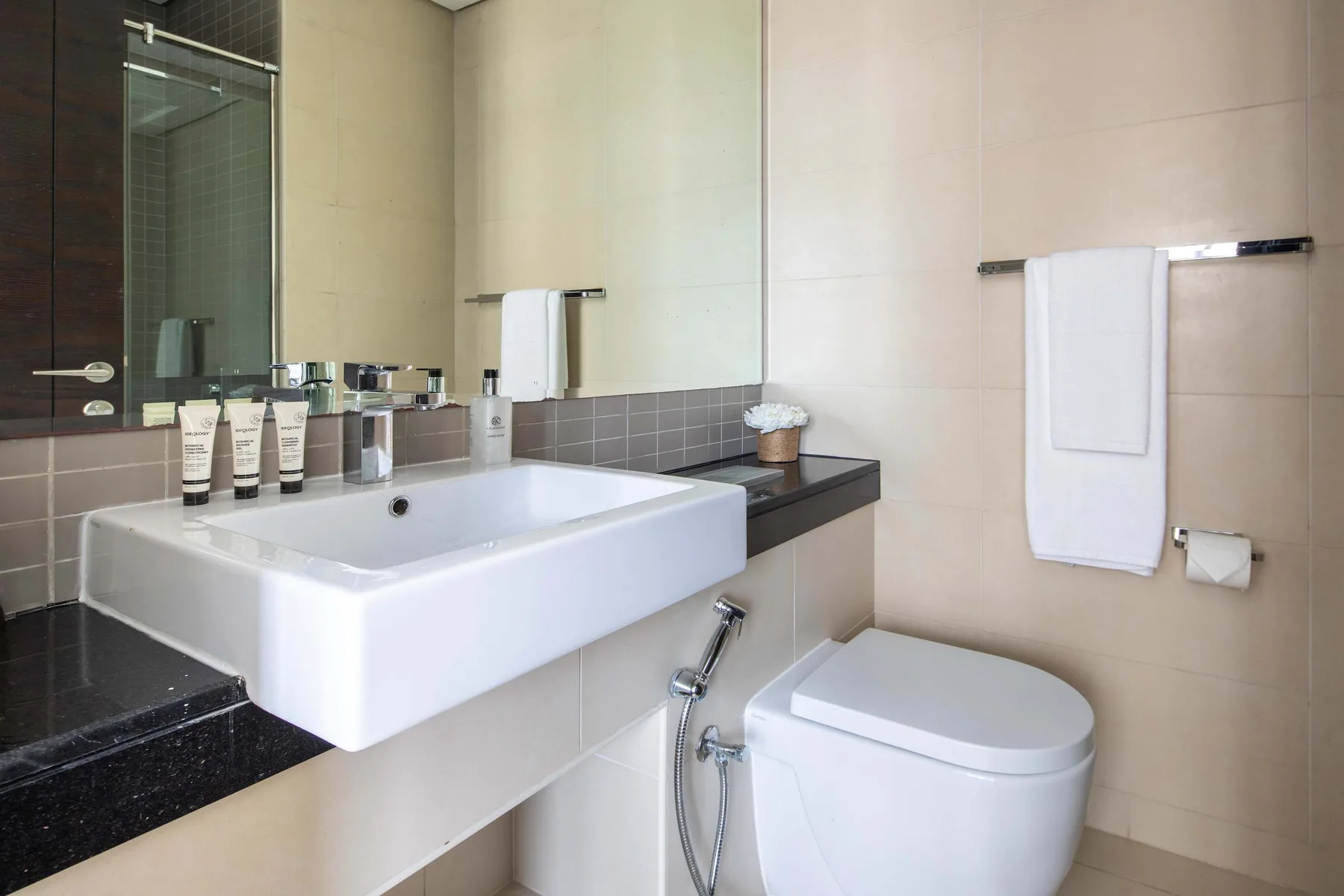 A bathroom with a sink, toilet, and towels hanging on the wall.