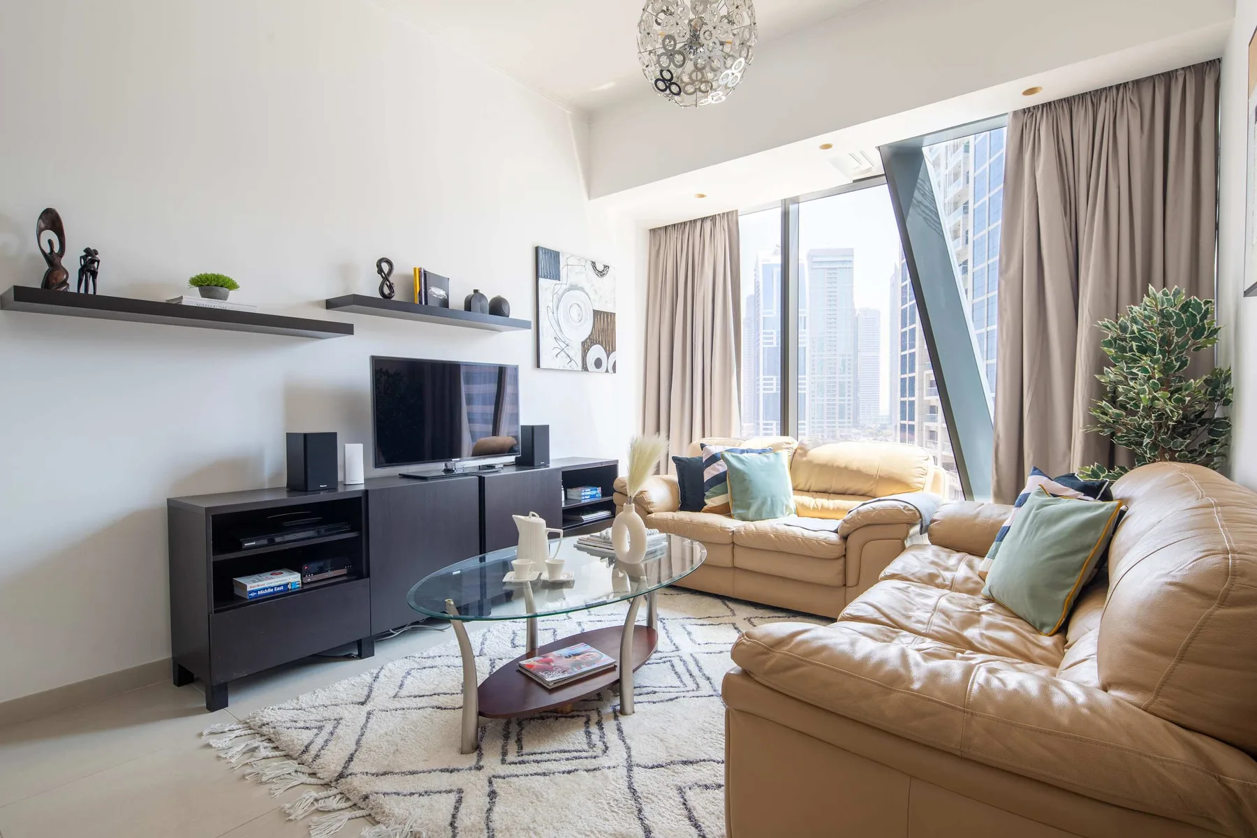 Una sala luminosa con asientos beige y una mesa de centro de vidrio.