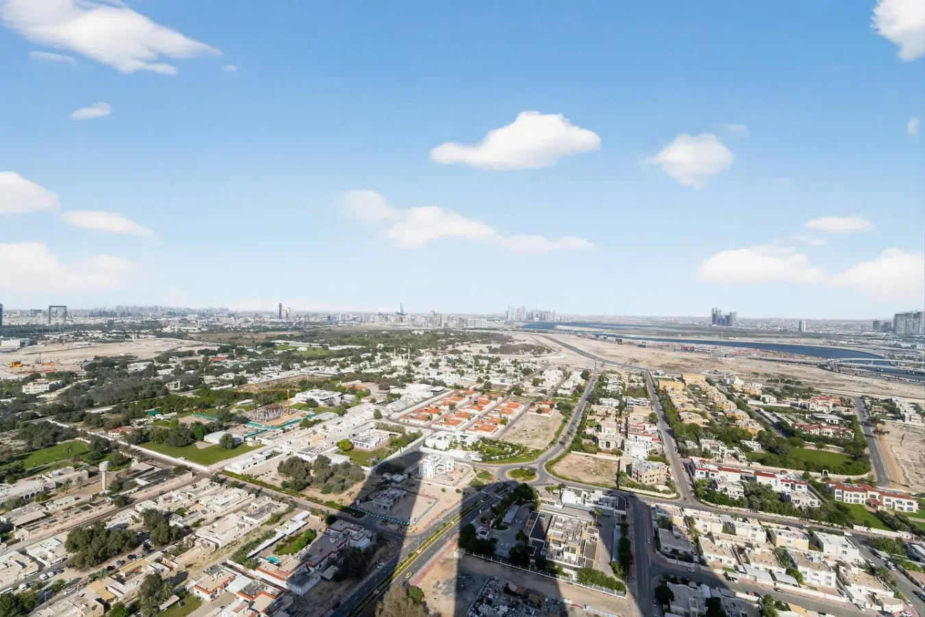 Vista aérea de una ciudad extensa bajo un cielo azul despejado.