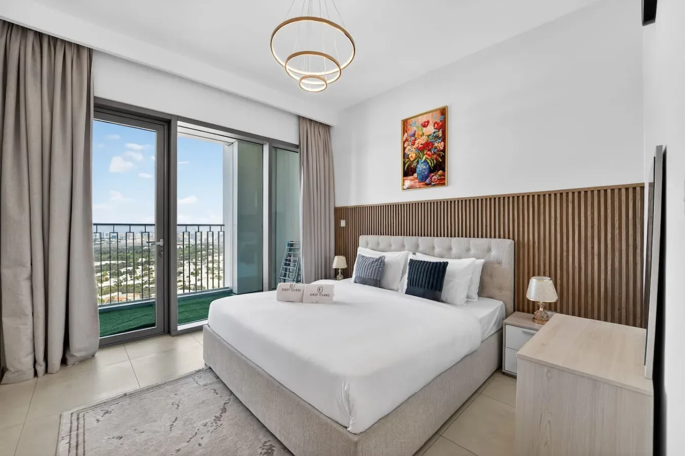 Un dormitorio luminoso con una cama grande y puertas de vidrio que dan a un balcón.