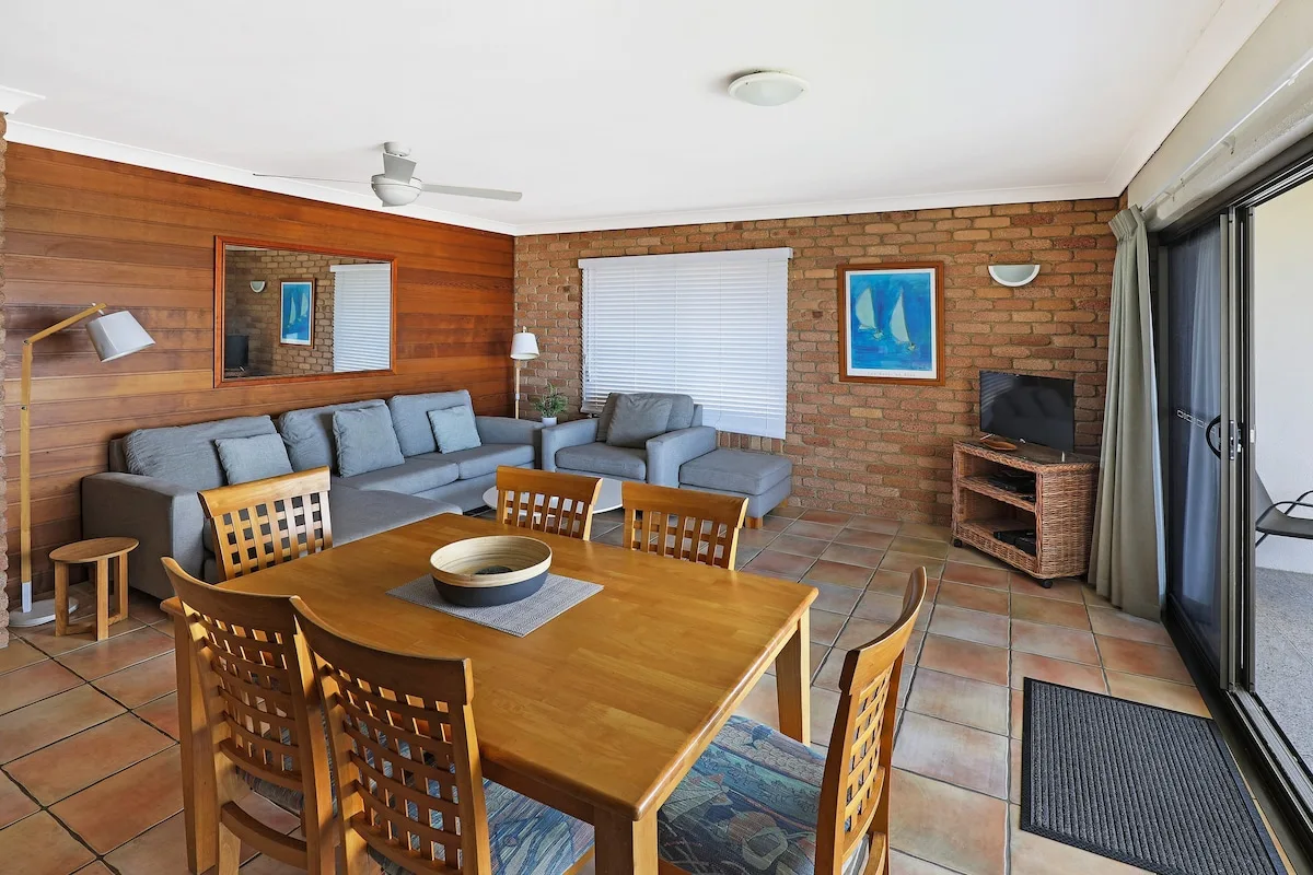 A living and dining room with wooden furniture and a seating area.