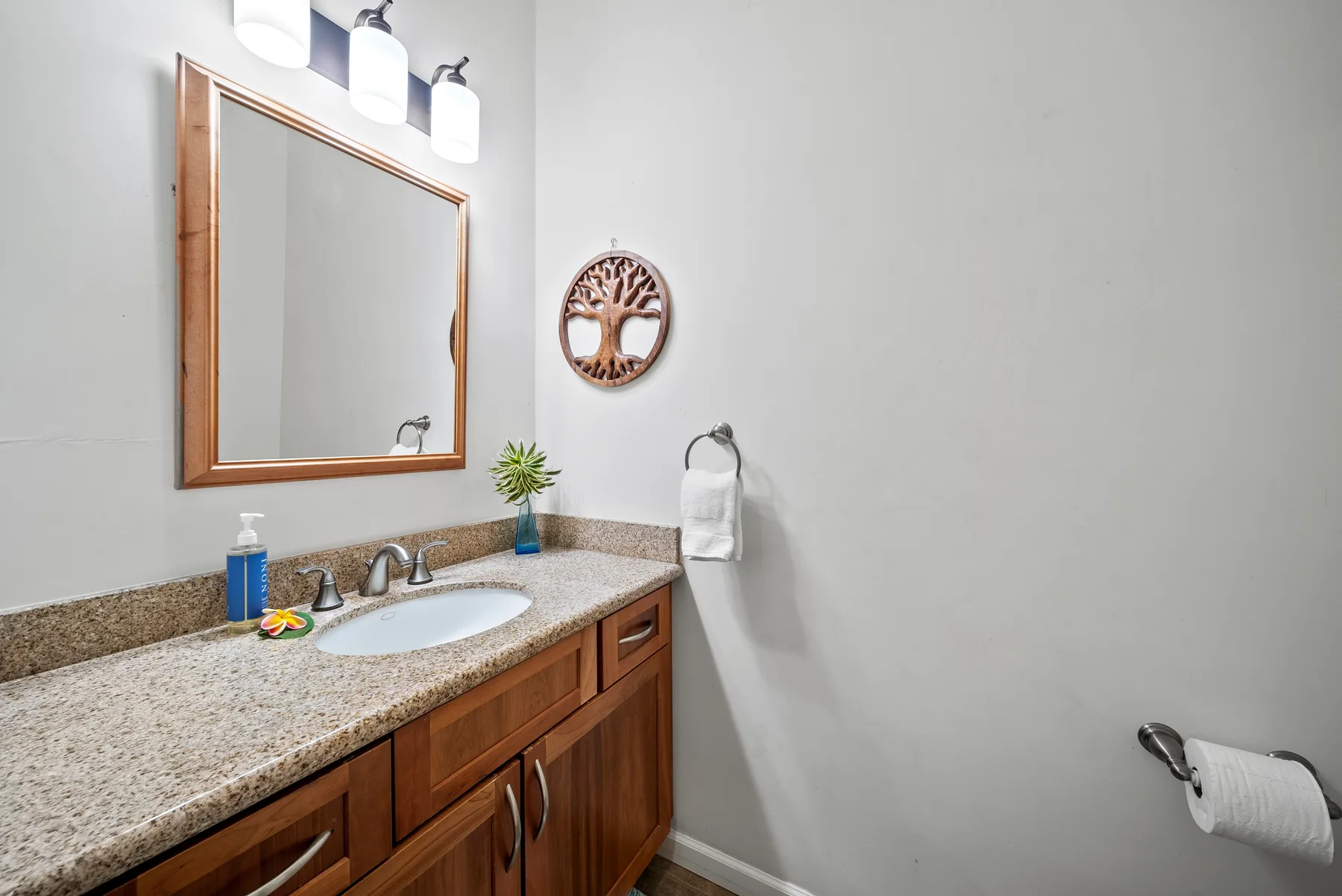 Un tocador de baño con lavabo y un espejo grande en la pared.