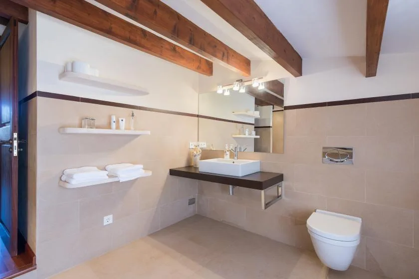 A modern bathroom with a wall-mounted sink and toilet.