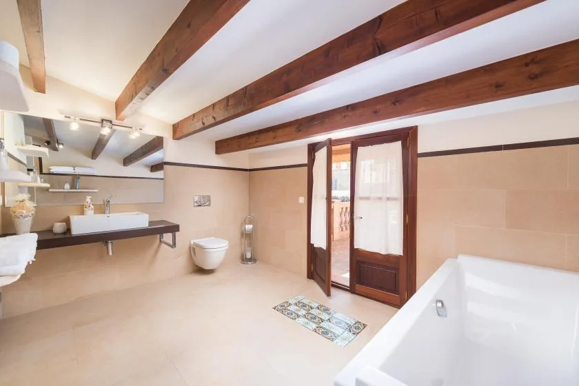 A spacious bathroom with a wall-mounted sink and a bathtub.