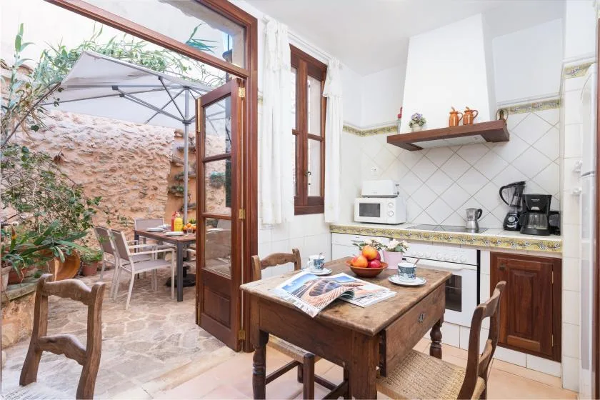 Una luminosa cocina con comedor se abre a un pequeño patio con asientos al aire libre.