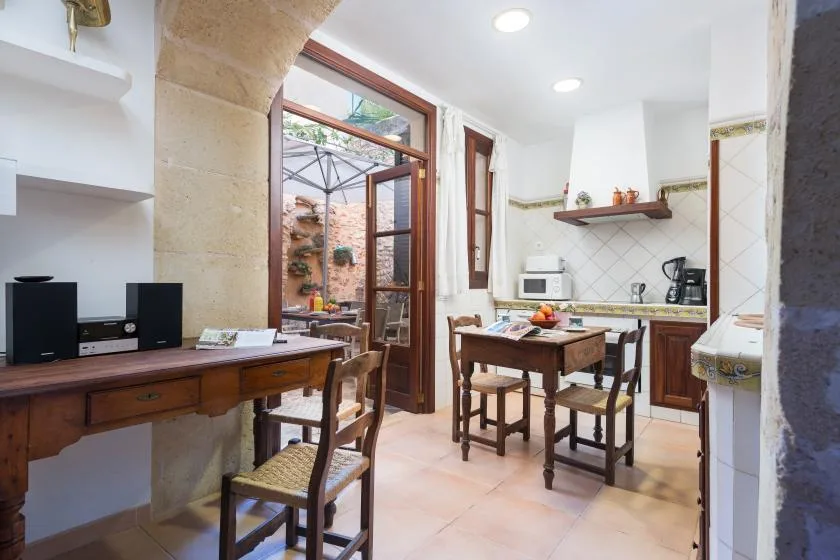 A bright kitchen with a wooden dining table and an open doorway to a patio.