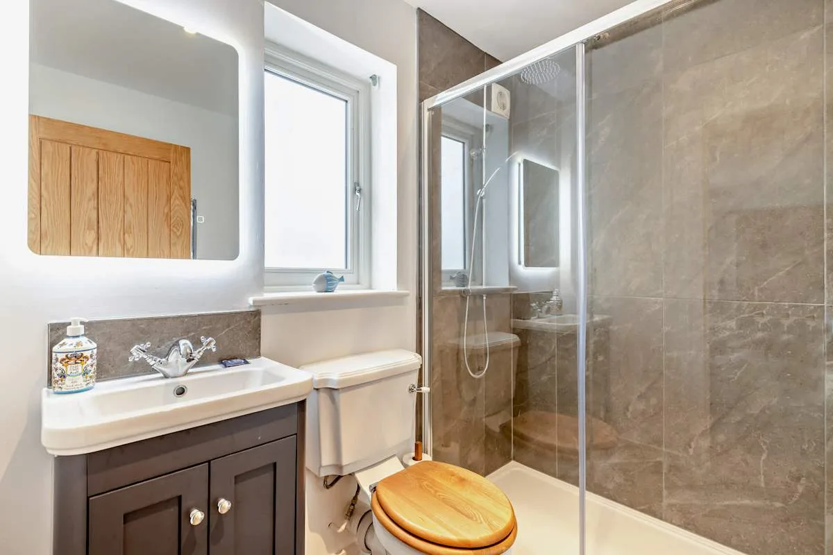 A bathroom with a sink, toilet, and glass shower.