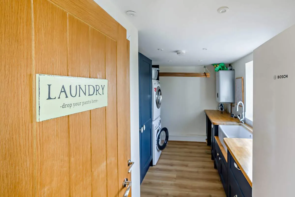 A laundry room with washing machines and a long counter.