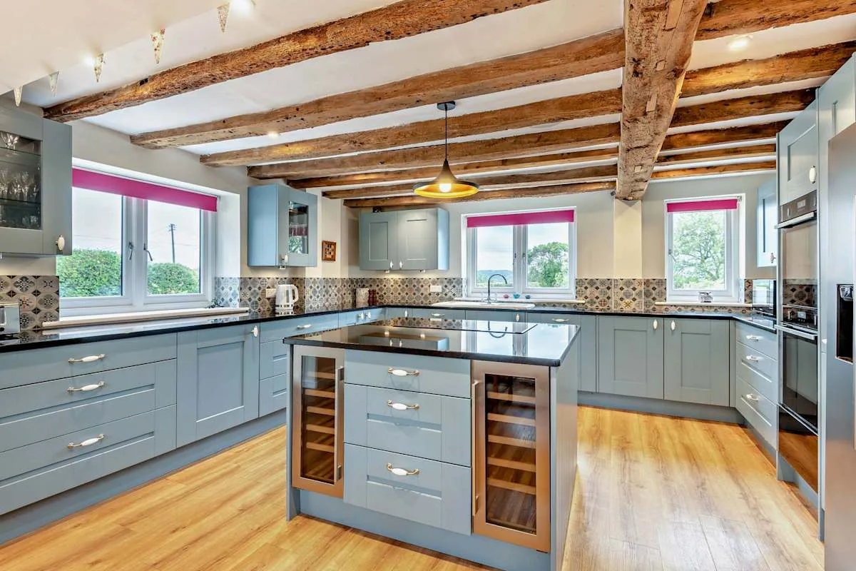A bright kitchen with blue-gray cabinets and a central island.