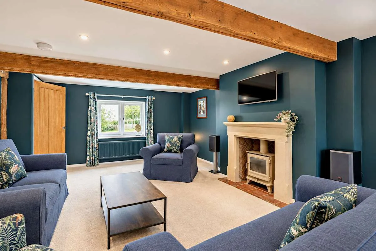 Living room with blue seating, a fireplace, and a television.