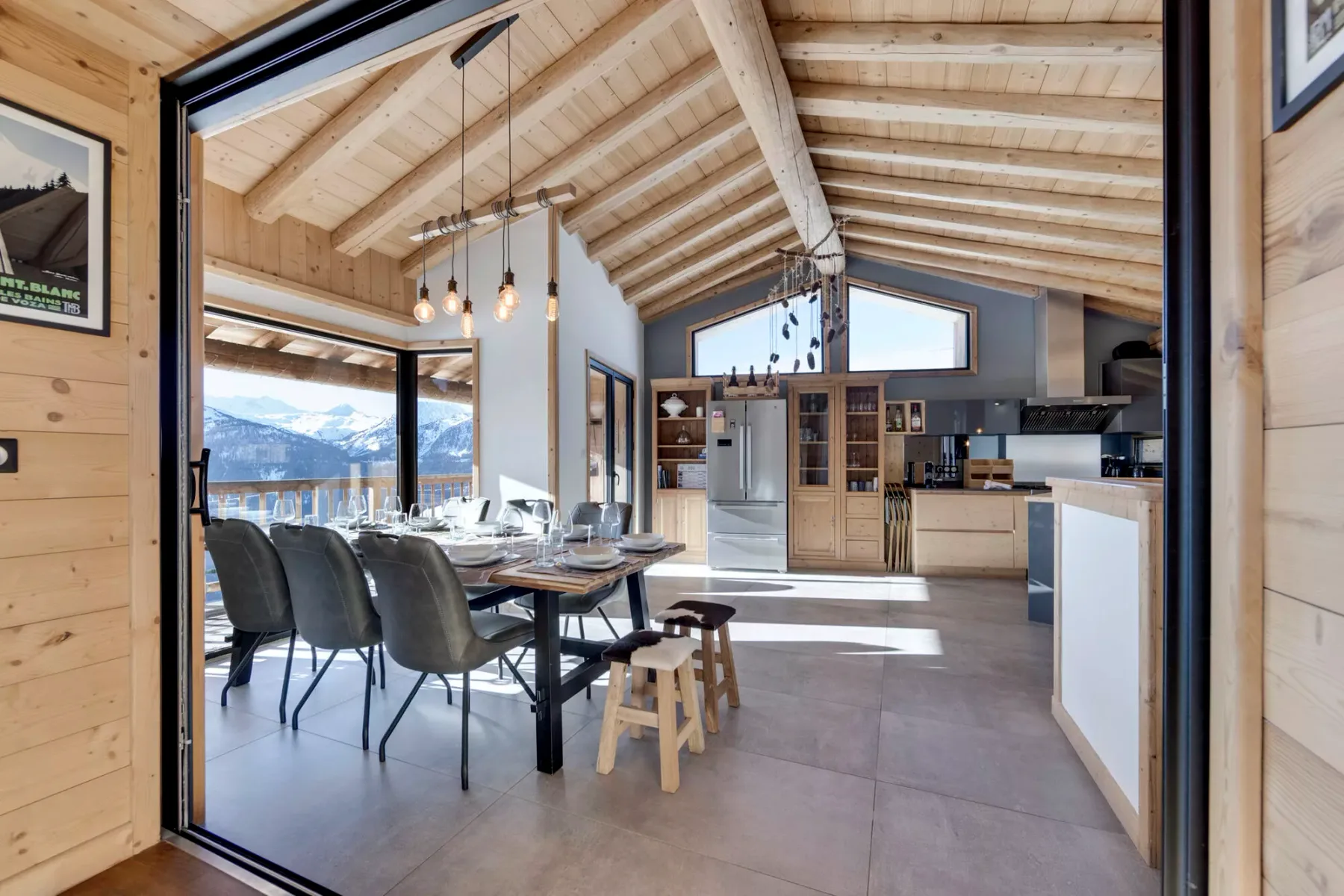 A bright open-plan kitchen and dining area with a high timber ceiling.