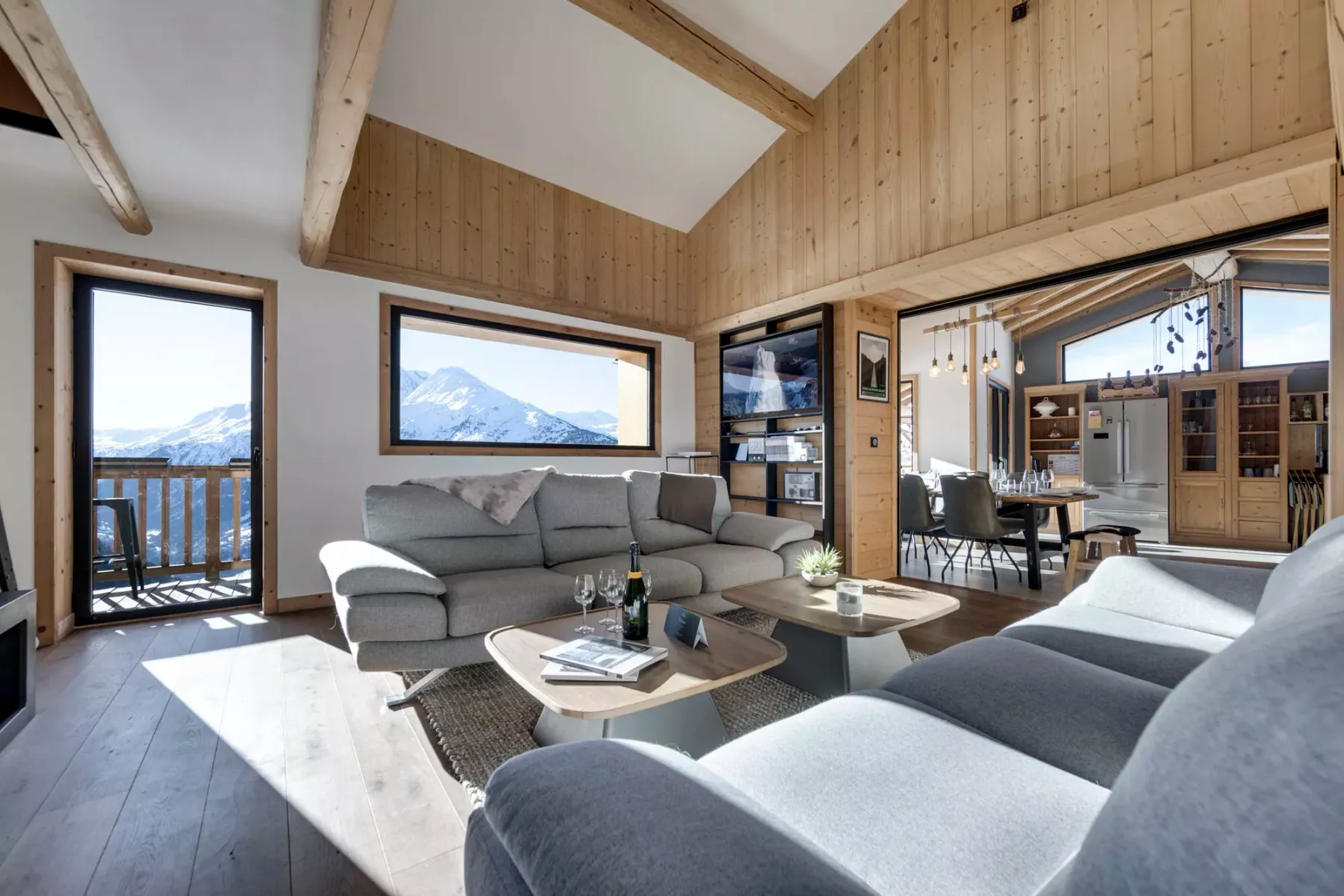 Living room with gray seating and large windows overlooking the mountains.