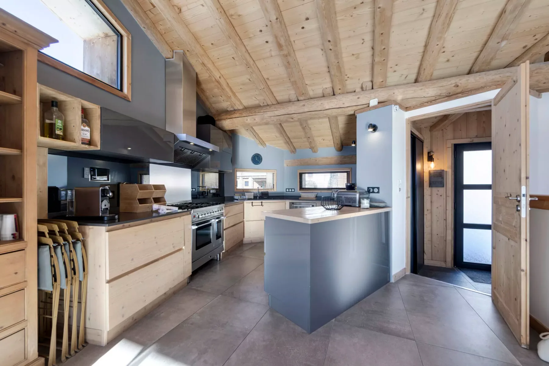 Una cocina luminosa con gabinetes de madera clara y una isla central.