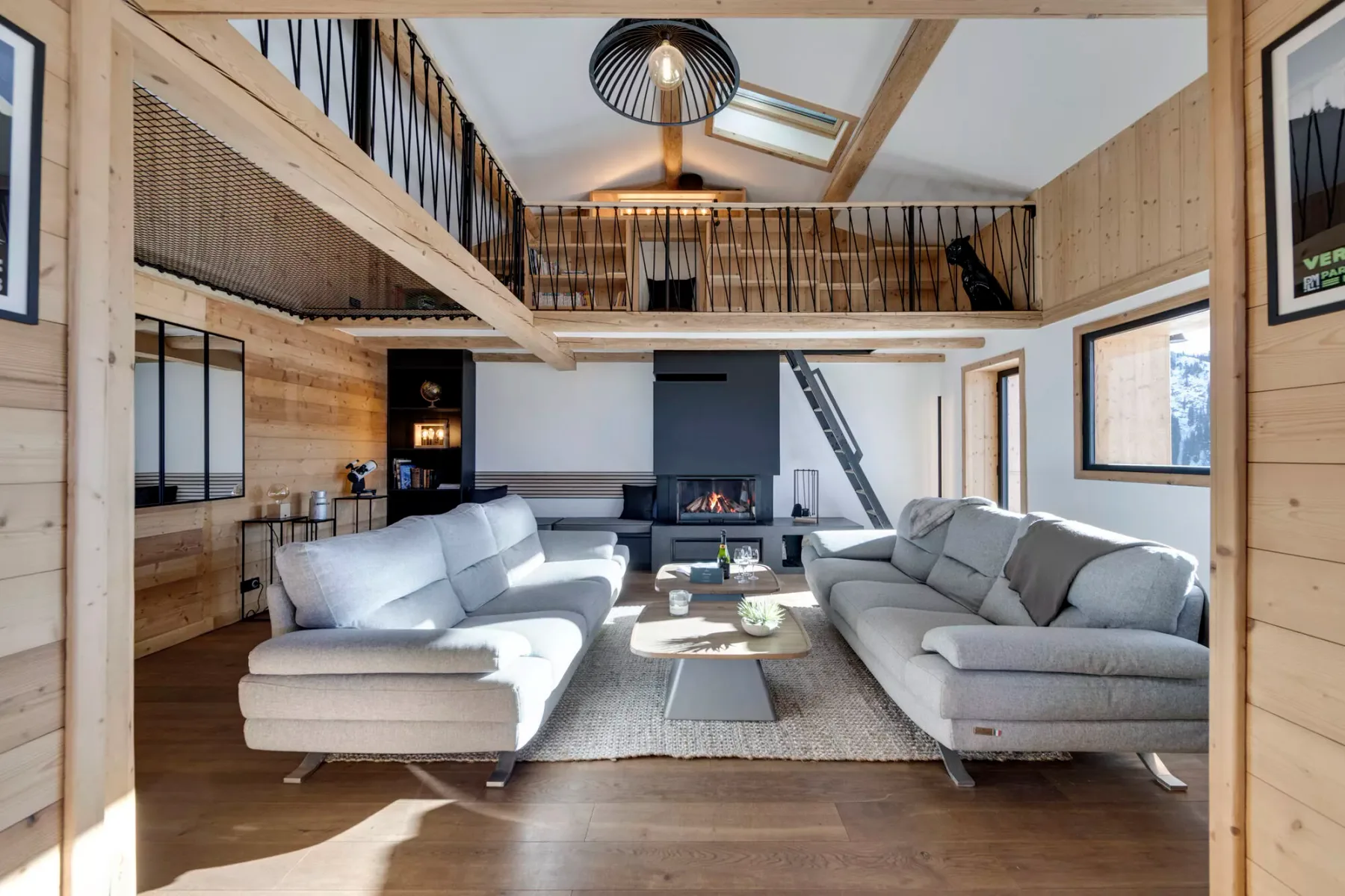 A spacious living room with seating arranged around a coffee table and fireplace.