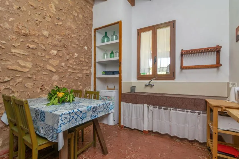 Un comedor con una mesa y sillas junto a una pared de piedra.