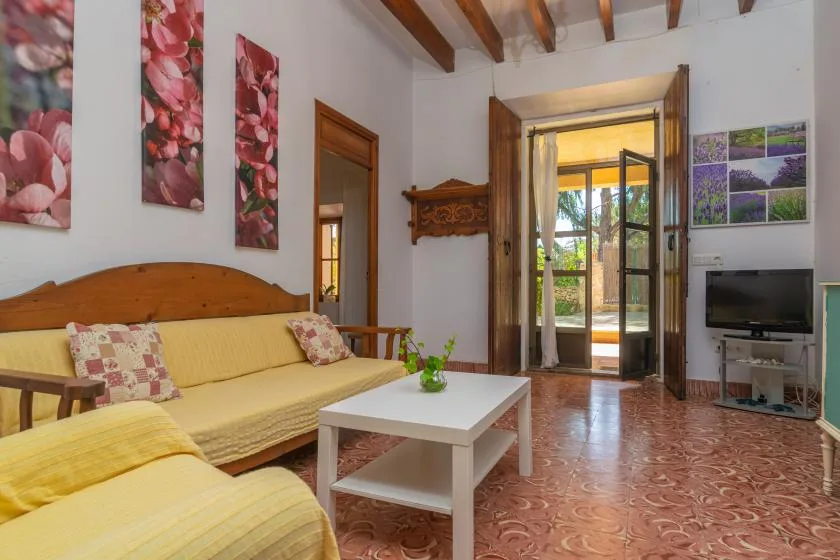 Una sala de estar con asientos, una mesa de centro y puertas de vidrio que dan a un patio.