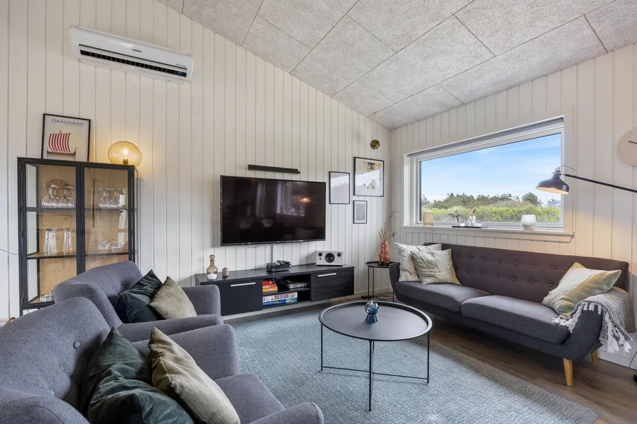 A living room with sofas, a television, and a round coffee table.