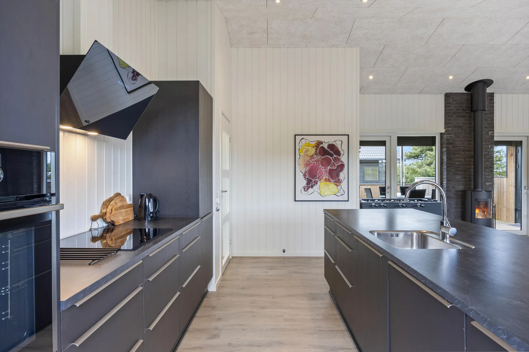 A modern kitchen with dark cabinets and a central island.