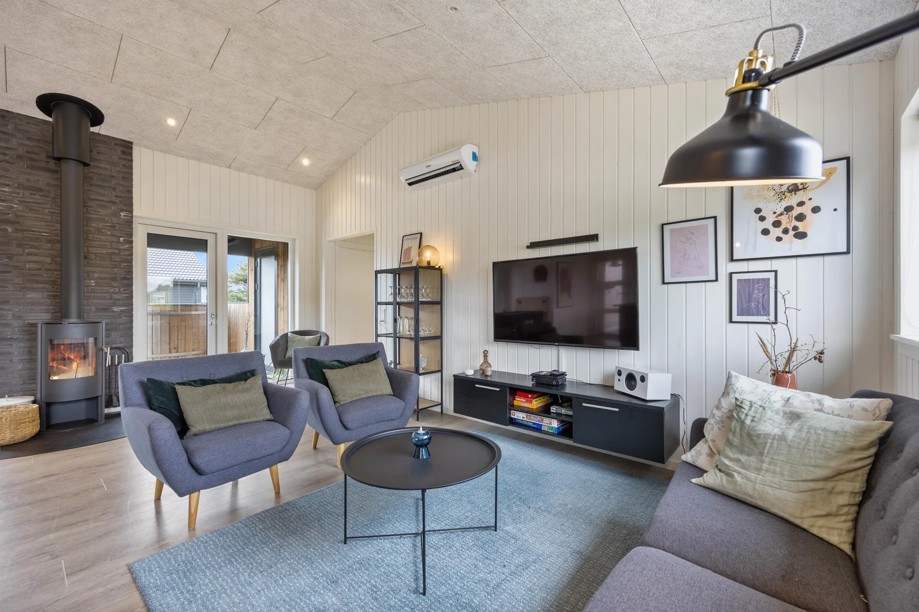 A living room with seating arranged around a coffee table and television.
