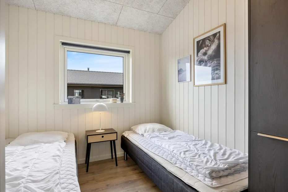 A bedroom with two single beds and a small table between them.