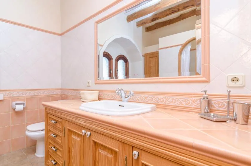 A bathroom vanity with a sink and a large wall mirror.