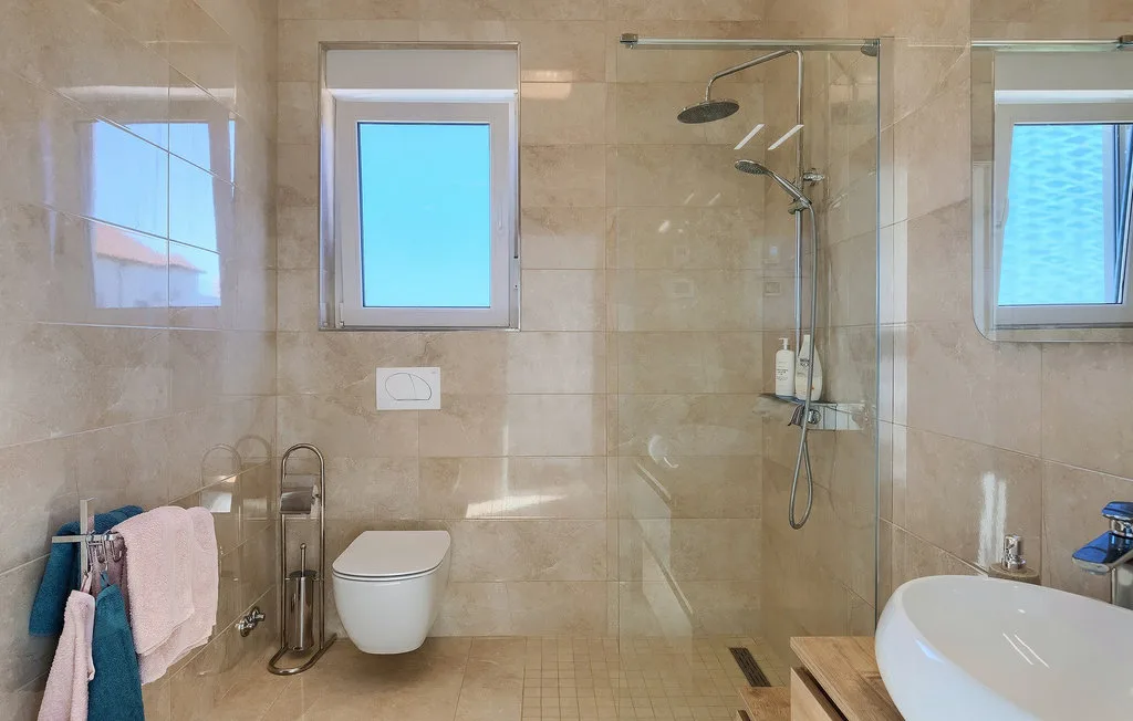Un baño alicatado con ducha, inodoro y bañera.