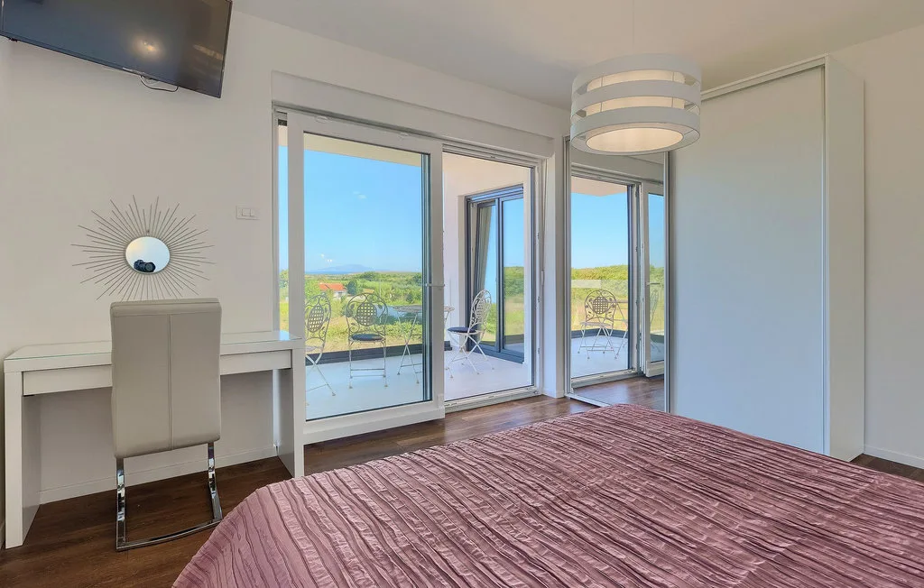 Un dormitorio con una cama junto a puertas de vidrio que dan a un balcón.
