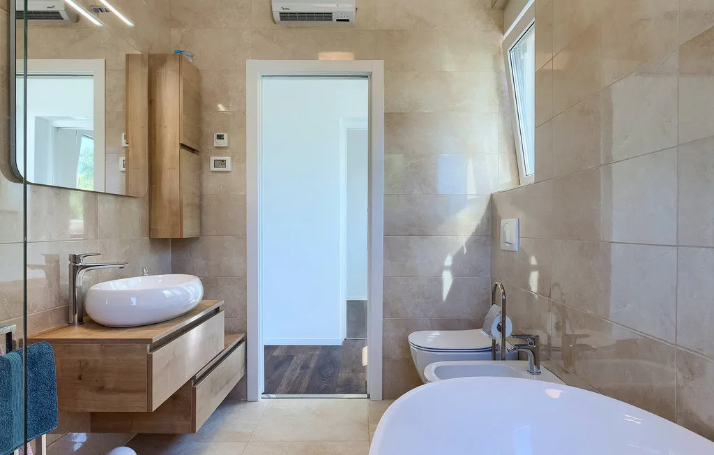 Un baño con azulejos, bañera, lavabo y una puerta.