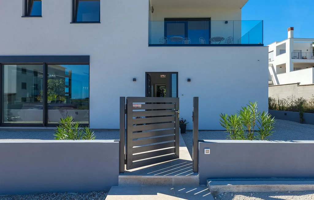 Entrada de un edificio moderno con una puerta metálica y puertas de vidrio.