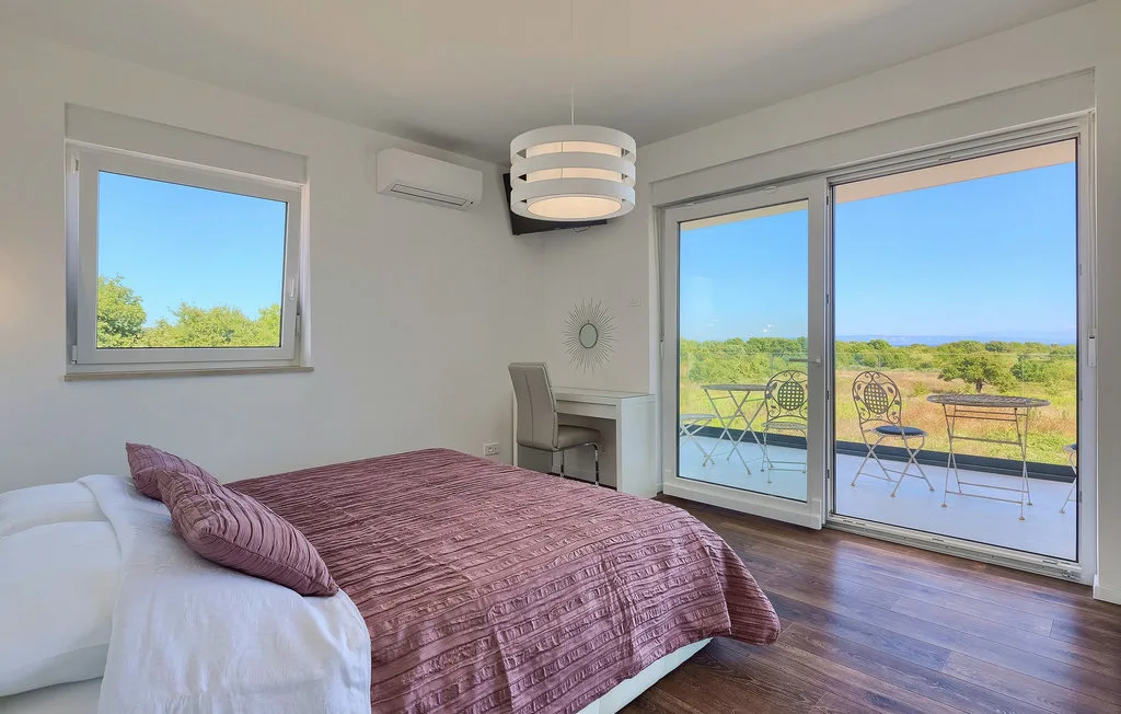 Un dormitorio con una cama junto a puertas de vidrio que dan a una terraza.