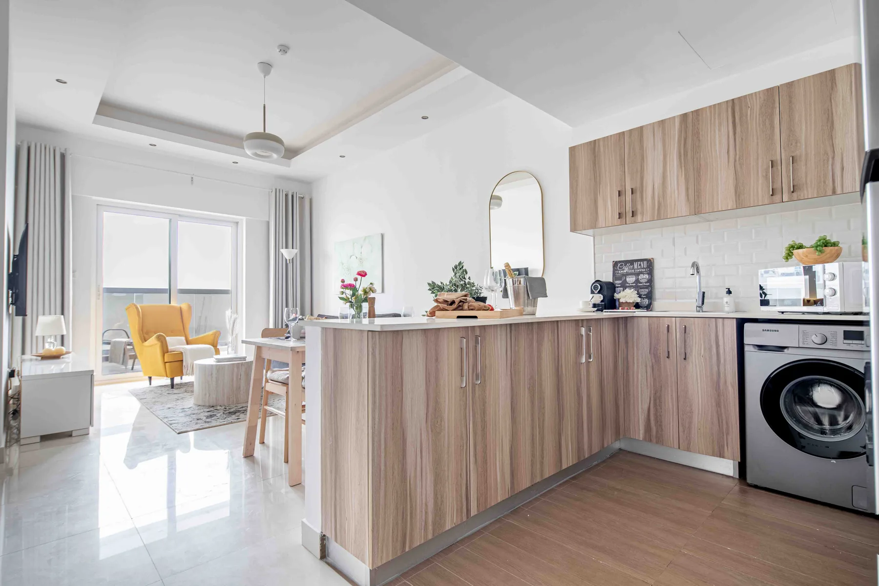Una cocina y comedor luminosos con una barra larga y asientos junto a las ventanas.