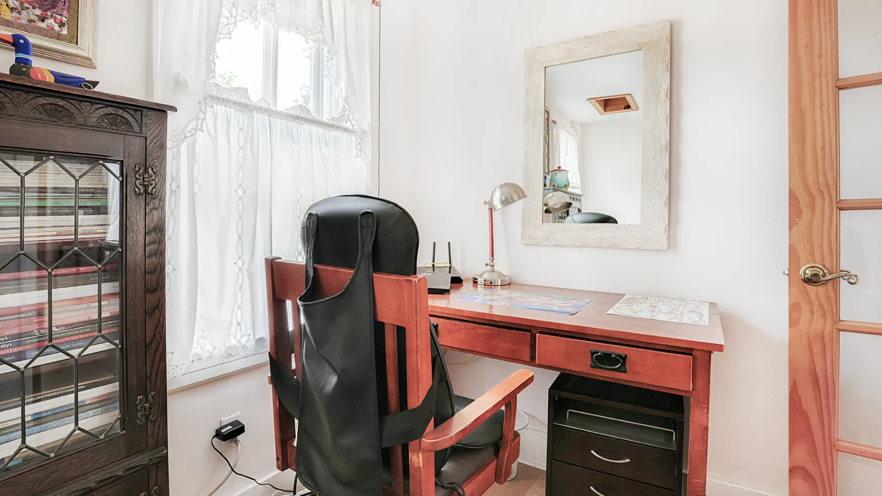 A bright study area with a desk, office chair, and large window.